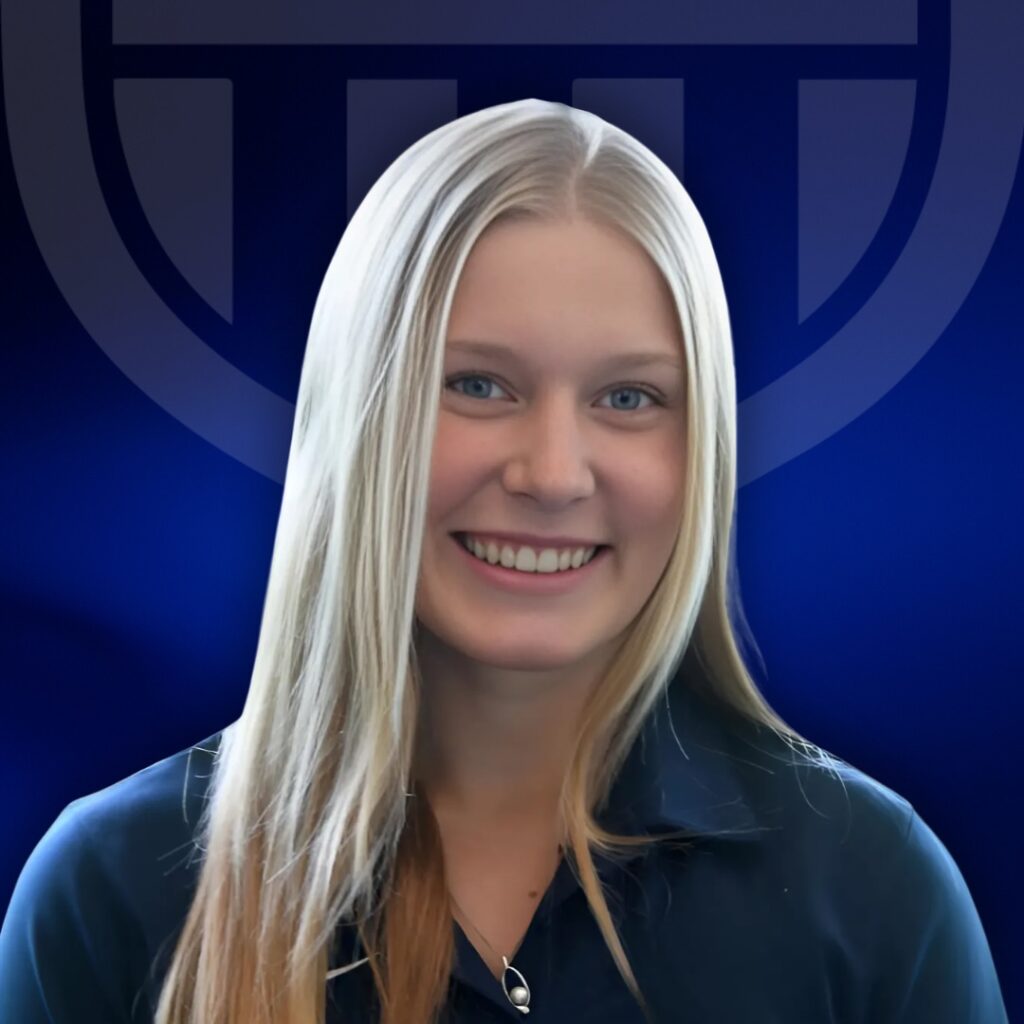 A young woman with long blonde hair smiles at the camera, wearing a dark collared shirt. The blue background features a bold geometric logo partially visible behind her, representing TPH Academy.