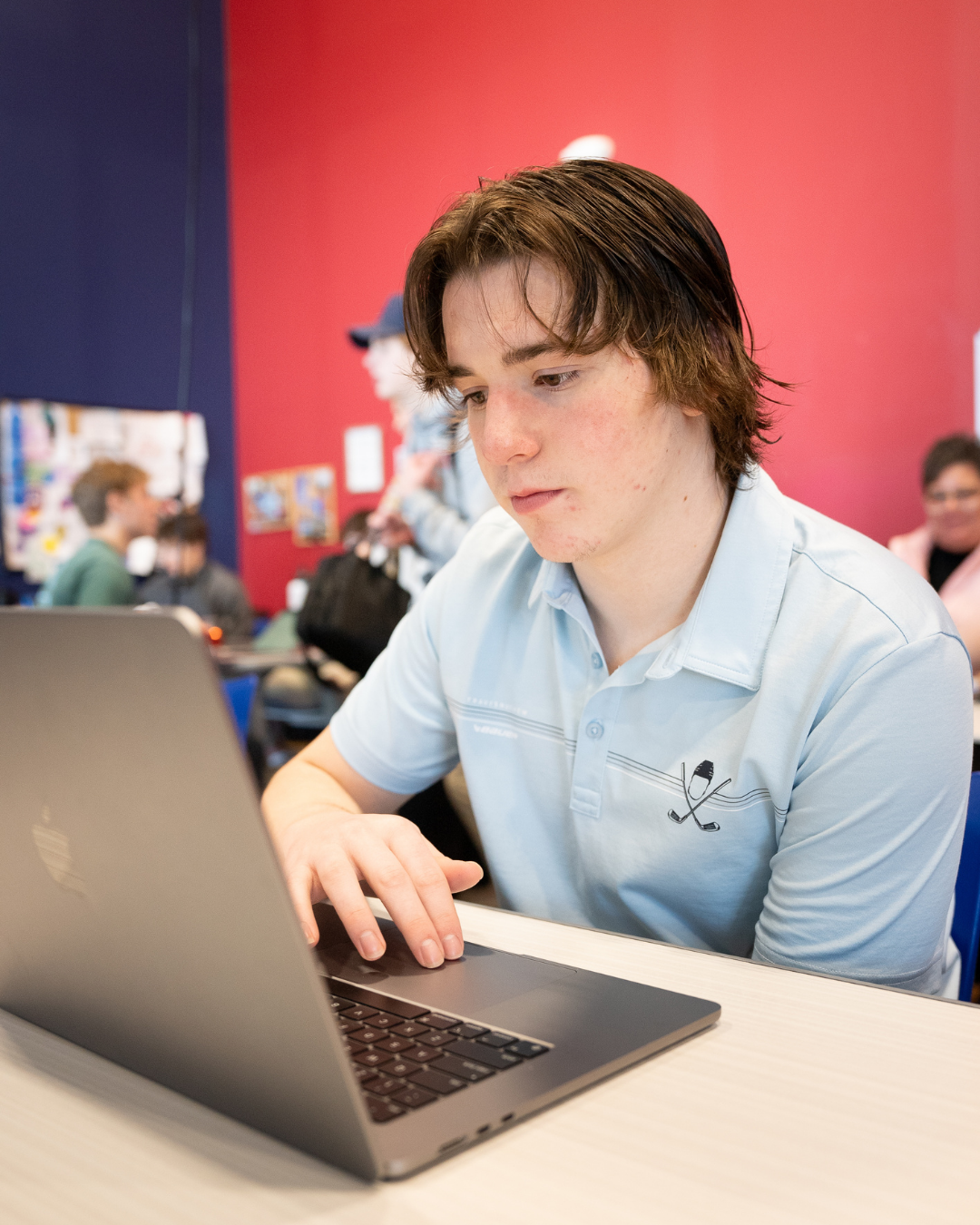 Close-up of a student looking at a laptop will doing schoolwork.