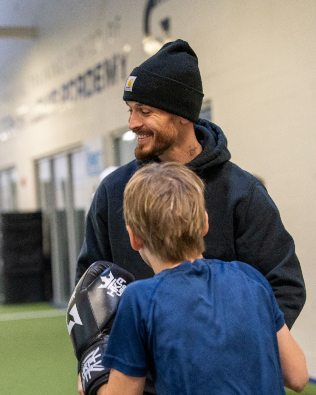 Coach smiling while giving instruction to TPH St. Louis Hockey Academy student.