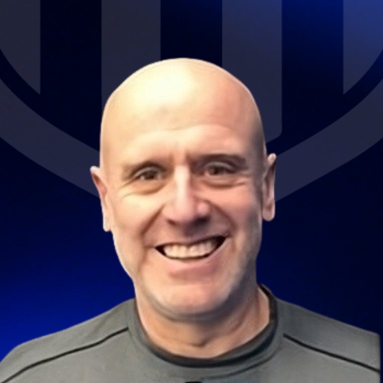 A smiling bald man wearing a dark gray shirt stands in front of a dark blue background with a subtle abstract design, representing TPH Academy.